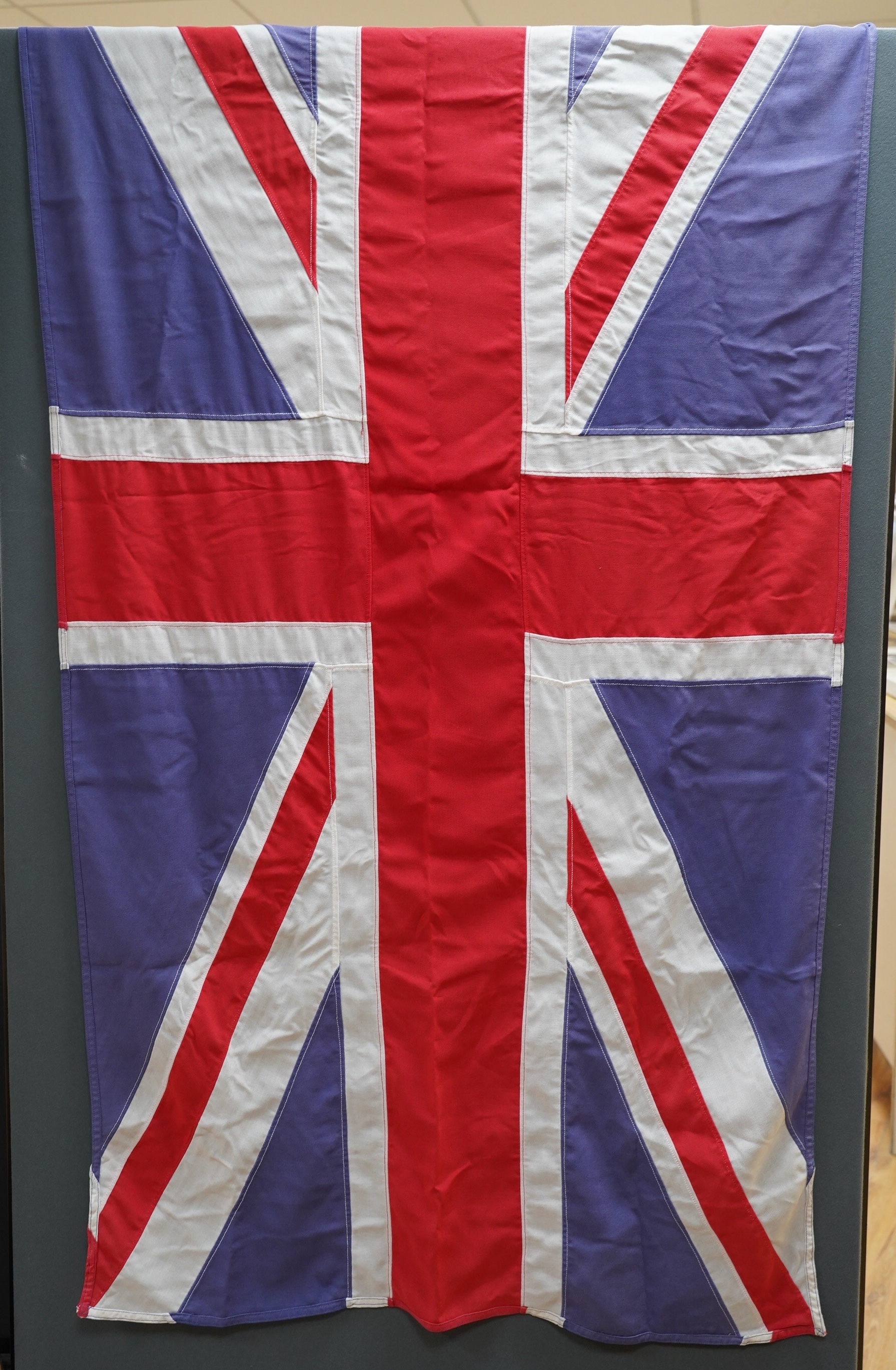 Eight mostly mid 20th century Union Jack flags, one celebrating Queen Victoria’s Diamond Jubilee, together with a Saint George’s cross and a string of Union flag bunting. Condition - poor to good